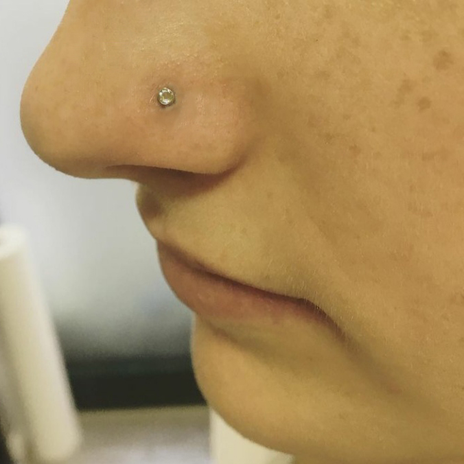 Detailfoto eines Nasenpiercings mit Stecker